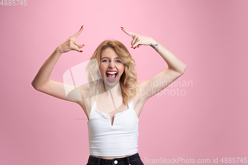 Image of Caucasian young woman\'s portrait isolated on pink studio background. Beautiful female model. Concept of human emotions, facial expression, sales, ad, youth culture.
