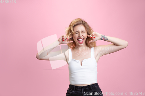 Image of Caucasian young woman\'s portrait isolated on pink studio background. Beautiful female model. Concept of human emotions, facial expression, sales, ad, youth culture.