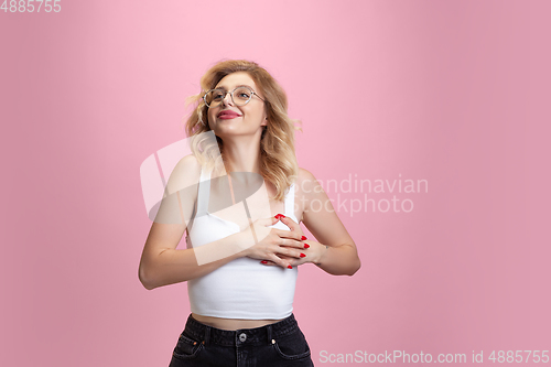 Image of Caucasian young woman\'s portrait isolated on pink studio background. Beautiful female model. Concept of human emotions, facial expression, sales, ad, youth culture.