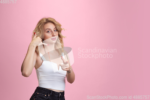 Image of Caucasian young woman\'s portrait isolated on pink studio background. Beautiful female model. Concept of human emotions, facial expression, sales, ad, youth culture.