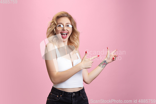 Image of Caucasian young woman\'s portrait isolated on pink studio background. Beautiful female model. Concept of human emotions, facial expression, sales, ad, youth culture.