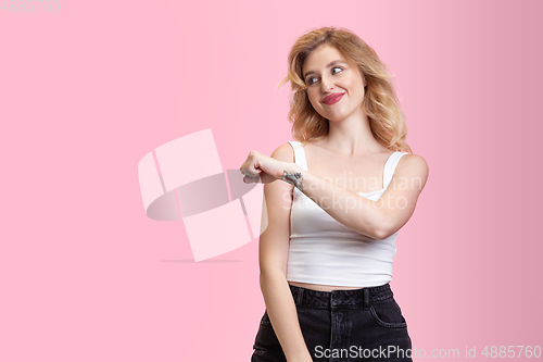 Image of Caucasian young woman\'s portrait isolated on pink studio background. Beautiful female model. Concept of human emotions, facial expression, sales, ad, youth culture.