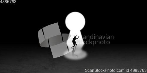 Image of Silhouette of man walking in the night toward the light, view from above