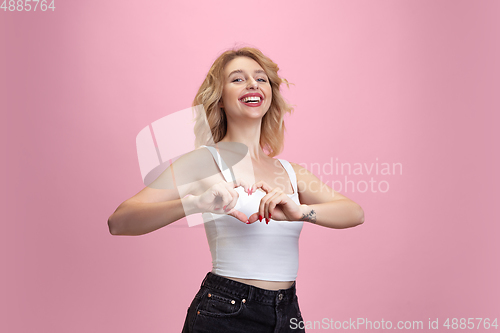 Image of Caucasian young woman\'s portrait isolated on pink studio background. Beautiful female model. Concept of human emotions, facial expression, sales, ad, youth culture.