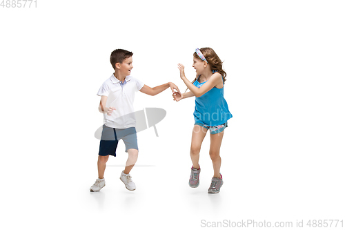 Image of Happy little caucasian girl and boy jumping and running isolated on white background