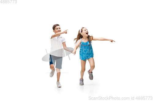 Image of Happy little caucasian girl and boy jumping and running isolated on white background