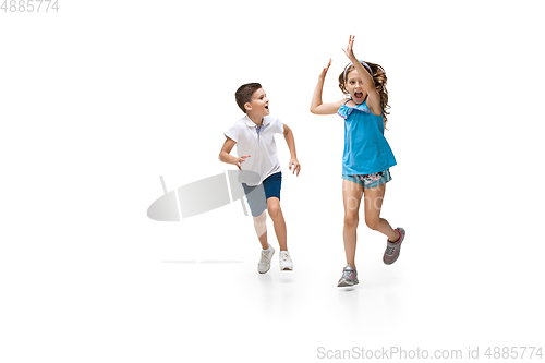 Image of Happy little caucasian girl and boy jumping and running isolated on white background