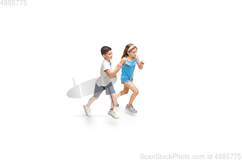 Image of Happy little caucasian girl and boy jumping and running isolated on white background