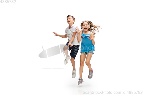 Image of Happy little caucasian girl and boy jumping and running isolated on white background