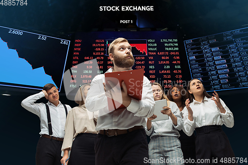 Image of Nervous tensioned investors analyzing crisis stock market with charts on screen on background, falling stock exchange