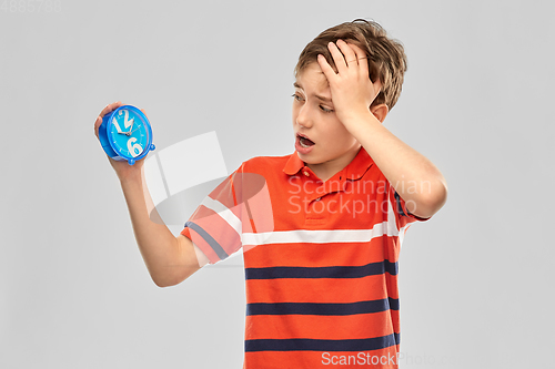 Image of portrait of boy with alarm clock