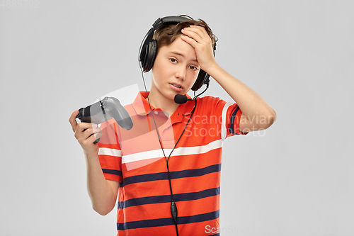 Image of boy in headphones with gamepad playing video game