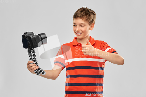Image of boy video blogger with camera showing thumbs up