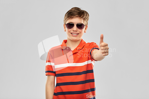 Image of smiling boy in sunglasses showing thumbs up