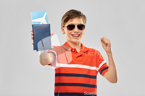 Image of happy boy in sunglasses with ticket and passport