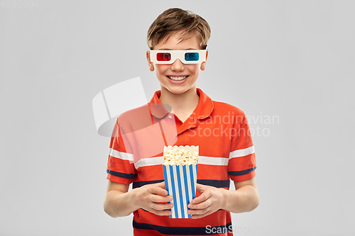 Image of smiling boy in 3d movie glasses eating popcorn