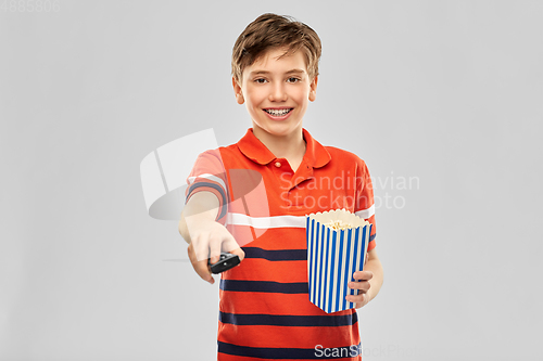 Image of smiling boy with popcorn and tv remote control