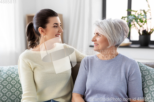 Image of senior mother with adult daughter talking at home