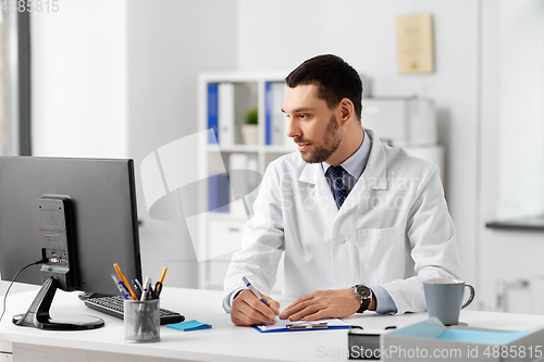 Image of doctor with clipboard and computer at hospital