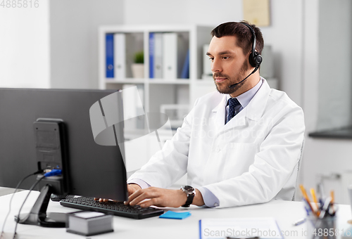 Image of male doctor with computer and headset at hospital