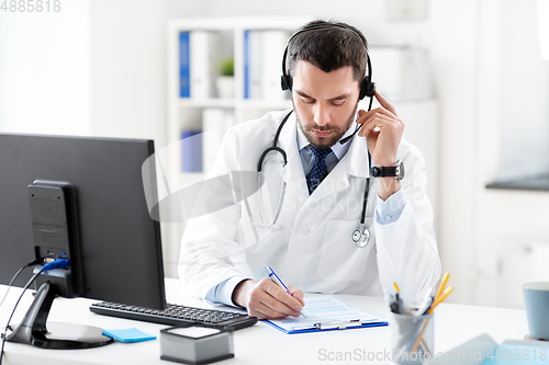 Image of male doctor with headset and clipboard at hospital