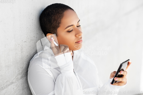 Image of african american woman with earphones and phone