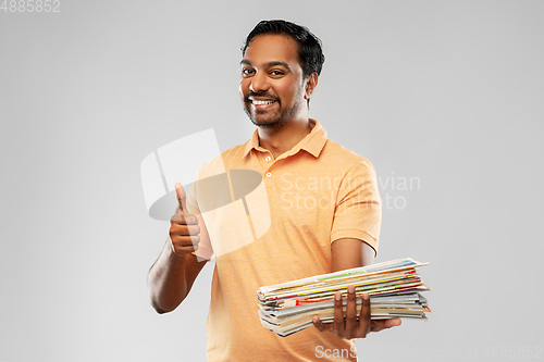 Image of indian man with paper waste showing thumbs up