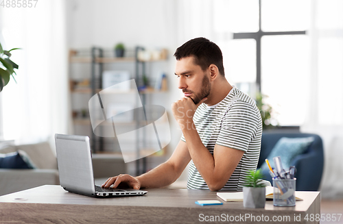 Image of man with laptop working at home office