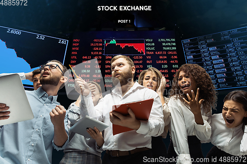 Image of Nervous tensioned investors analyzing crisis stock market with charts on screen on background, falling stock exchange