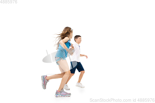 Image of Happy little caucasian girl and boy jumping and running isolated on white background