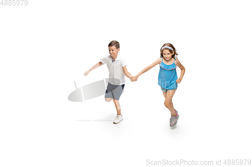 Image of Happy little caucasian girl and boy jumping and running isolated on white background