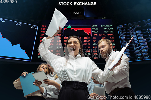 Image of Nervous tensioned investors analyzing crisis stock market with charts on screen on background, falling stock exchange