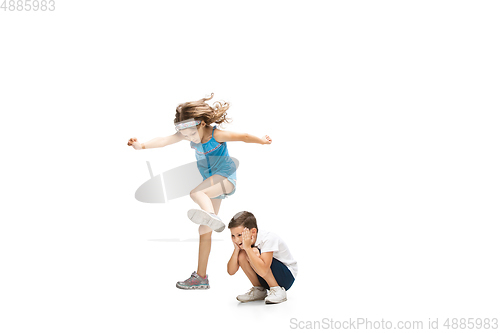 Image of Happy little caucasian girl and boy jumping and running isolated on white background