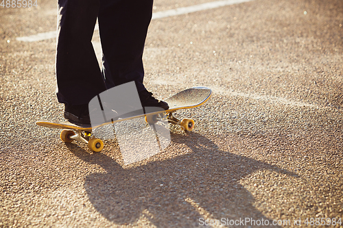 Image of Skateboarder doing a trick at the city\'s street in summer\'s sunshine