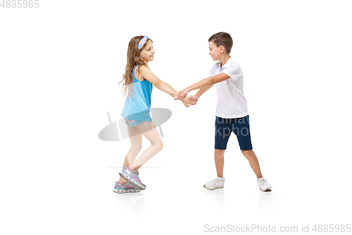 Image of Happy little caucasian girl and boy jumping and running isolated on white background