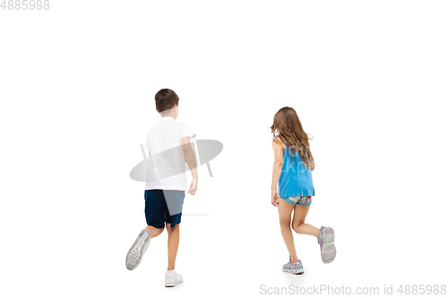 Image of Happy little caucasian girl and boy jumping and running isolated on white background
