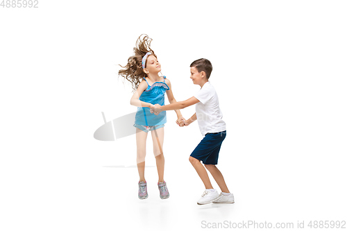 Image of Happy little caucasian girl and boy jumping and running isolated on white background