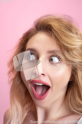 Image of Caucasian young woman\'s portrait isolated on pink studio background. Beautiful female model. Concept of human emotions, facial expression, sales, ad, youth culture.