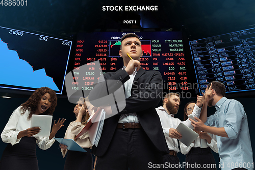 Image of Nervous tensioned investors analyzing crisis stock market with charts on screen on background, falling stock exchange