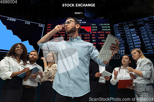 Image of Nervous tensioned investors analyzing crisis stock market with charts on screen on background, falling stock exchange