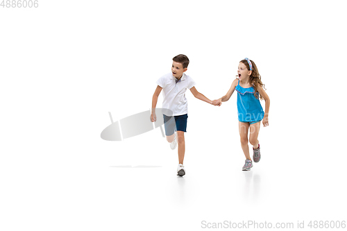 Image of Happy little caucasian girl and boy jumping and running isolated on white background