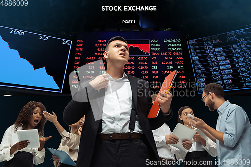 Image of Nervous tensioned investors analyzing crisis stock market with charts on screen on background, falling stock exchange