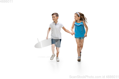Image of Happy little caucasian girl and boy jumping and running isolated on white background
