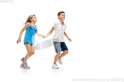 Image of Happy little caucasian girl and boy jumping and running isolated on white background