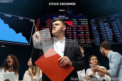 Image of Nervous tensioned investors analyzing crisis stock market with charts on screen on background, falling stock exchange