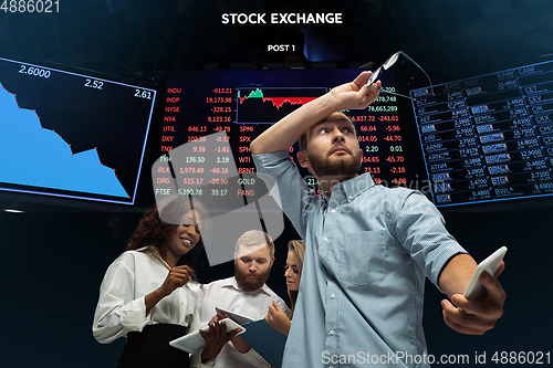 Image of Nervous tensioned investors analyzing crisis stock market with charts on screen on background, falling stock exchange