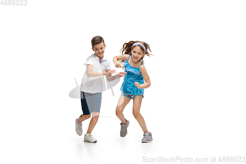 Image of Happy little caucasian girl and boy jumping and running isolated on white background