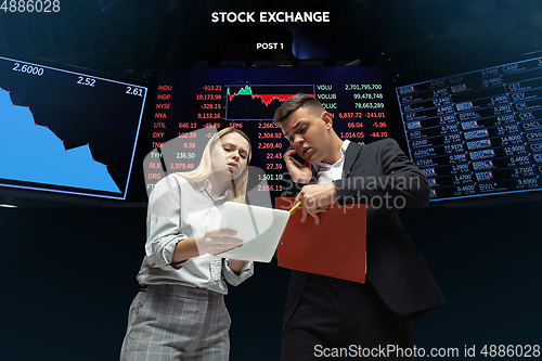 Image of Nervous tensioned investors analyzing crisis stock market with charts on screen on background, falling stock exchange