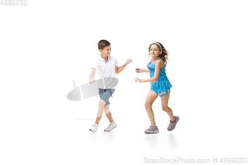 Image of Happy little caucasian girl and boy jumping and running isolated on white background