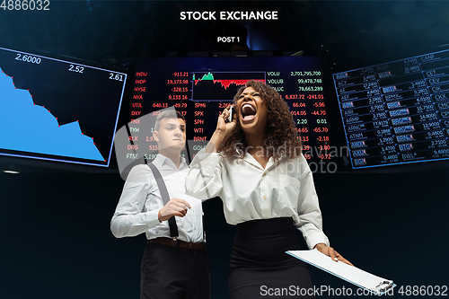 Image of Nervous tensioned investors analyzing crisis stock market with charts on screen on background, falling stock exchange